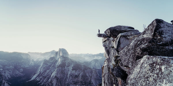 Phobia, fear of heights, high mountain man standing on edge looking down anxiety