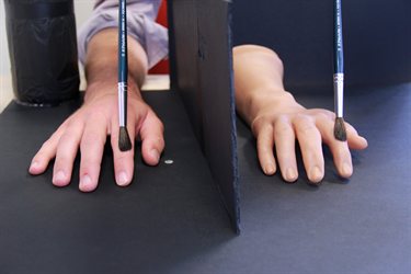 Hands being stroked by a paintbrush