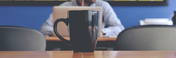 @javiermolina Coffee cup and man staring off into the distance in cafe