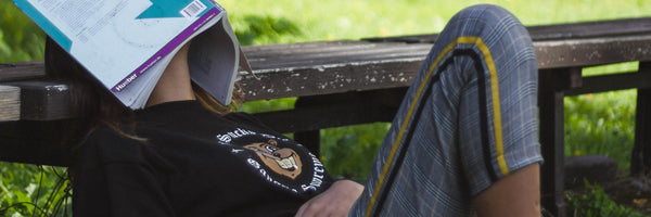 @tonny.tran girl sitting with book on her face tired from studying and working
