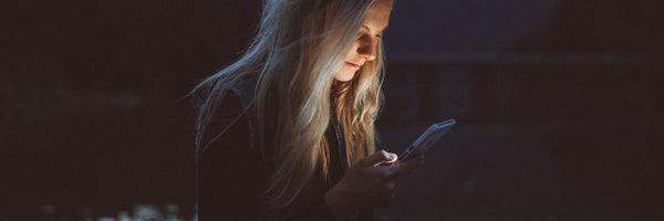 Woman using phone in the dark
